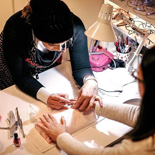 Stainless steel nail clipper in hands during nail trimming, metal cutting edge visible