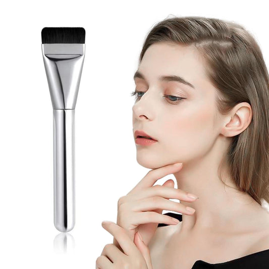 Flat foundation makeup brush beside face, black bristles on silver handle
