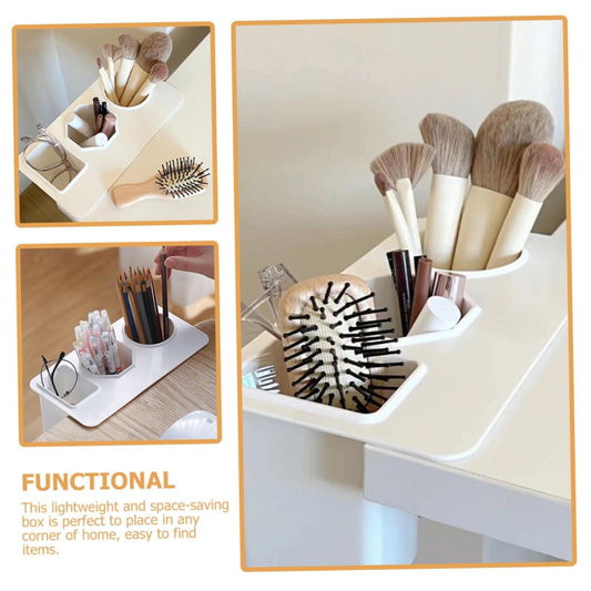 White desk organizer tray with three compartments holding makeup brushes and pencils