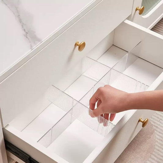 Transparent drawer divider grid with clips, being placed in an open drawer