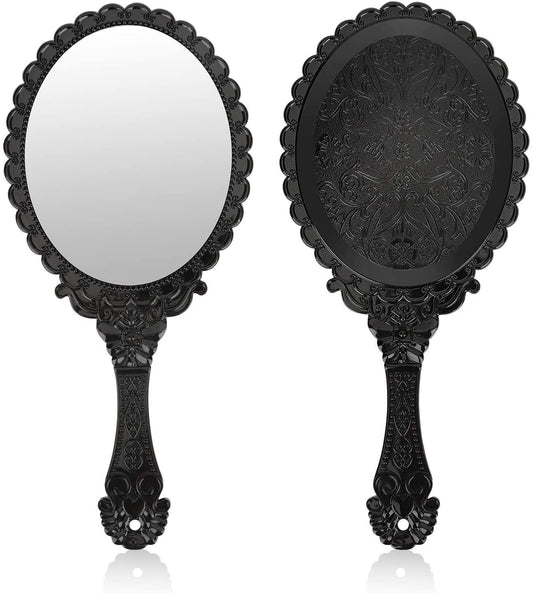 Black handheld decorative mirror with ornate scalloped frame and embossed flower handle