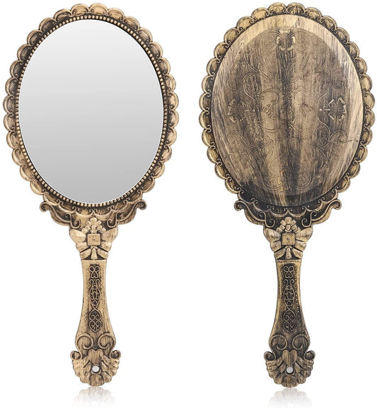 Handheld vintage-style mirror with ornate floral embossed gold-toned frame