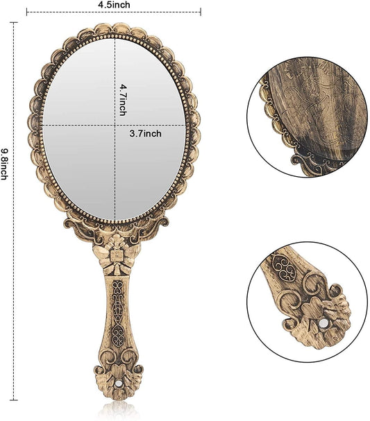Small handheld oval mirror with detailed filigree gold-toned frame and handle