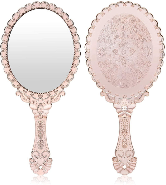 Rose gold oval handheld vanity mirror with scalloped filigree frame and floral embossing