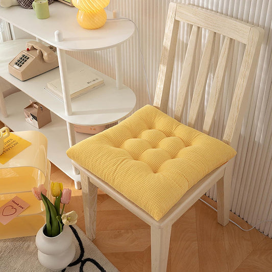 Yellow corduroy chair seat cushion with quilted tufted center, square design.