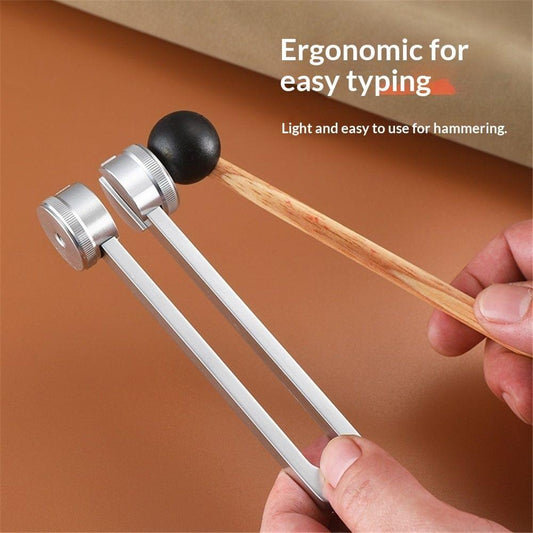 Metal tuning forks with wooden handles held by hand, black hammer tips