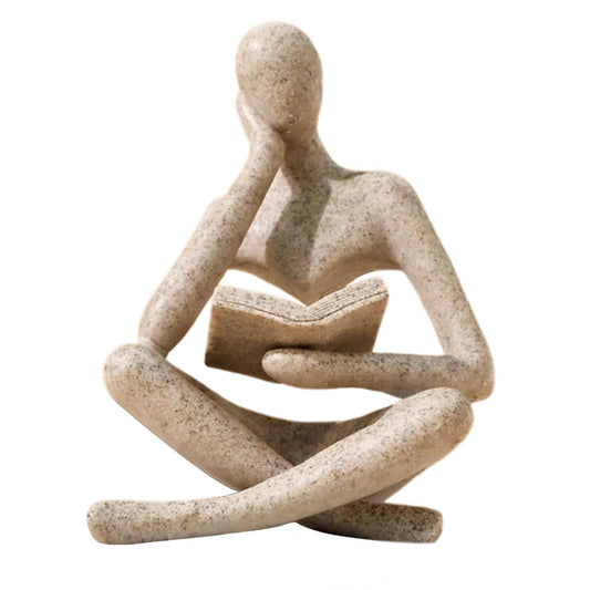 Beige reading thinker statue figurine, close kneeling reading with open book