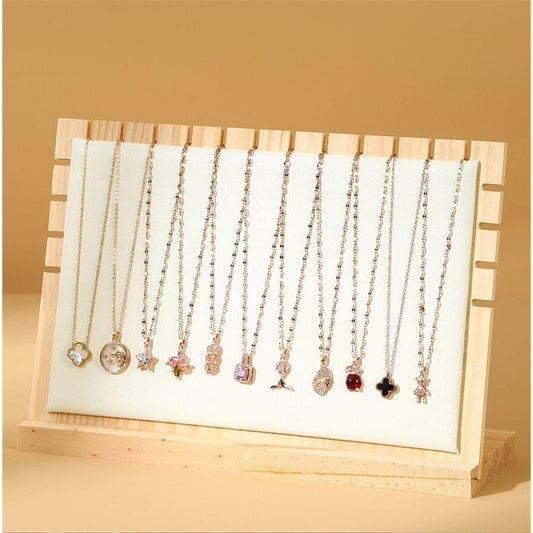 Beige tabletop necklace display stand with pins and multiple hanging pendant necklaces