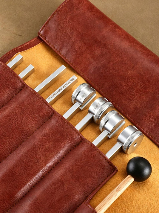 Tuning fork set in brown pouch with multiple metal forks and black ball