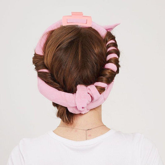 Pink satin hair curler wrap and rollers on head, with plastic clips