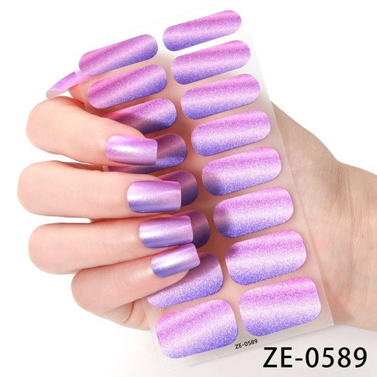 Purple glitter nail stickers set on backing film with curved, full-coverage tips