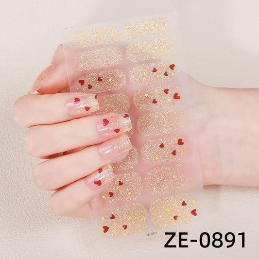 Nail stickers with gold glitter and red heart confetti on a clear strip sheet