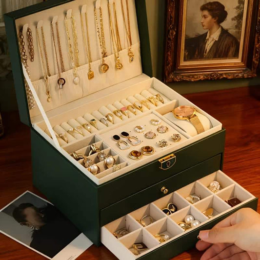 Dark green jewelry storage box open with velvet-lined trays, necklace hooks, and drawers
