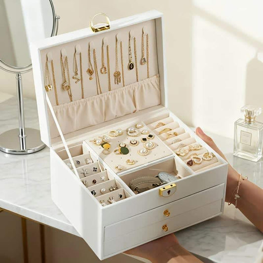 White jewelry storage box with open lid and compartments for necklaces and rings