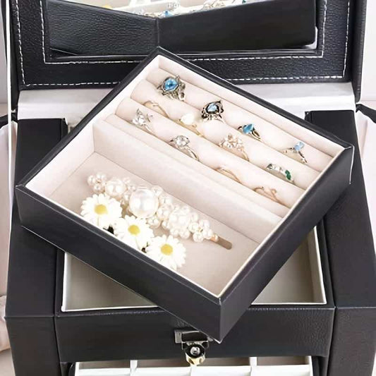 Black jewelry box with open lid showing ring and earring compartments with padded insert