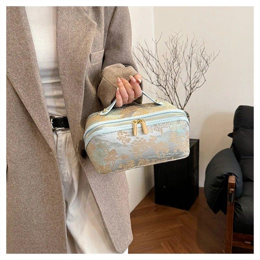 Blue patterned toiletry bag with carry handle and double gold zipper pulls