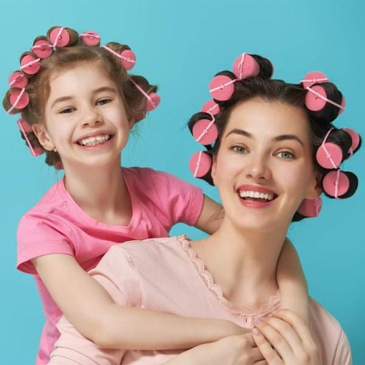 Pink foam hair rollers in hair on two people, large curlers for styling