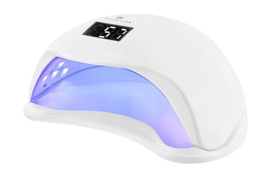 White UV nail lamp with curved base and glowing blue light inside.
