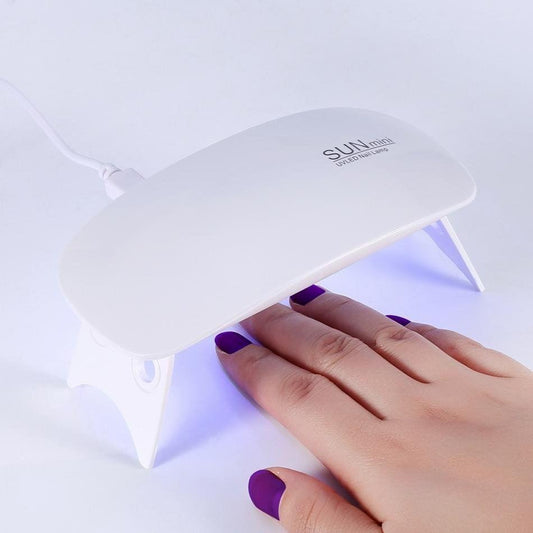 White UV LED nail lamp with hand inside, curing gel nails under the hood