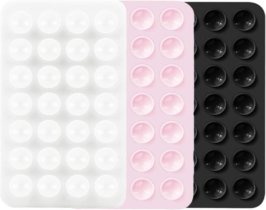 Three suction pad sheets: white, pink, and black with raised circular bumps