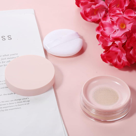 Pink compact powder case with open lid, sifter mesh and white sponge puff.
