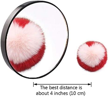 Round magnifying makeup mirror with black rim beside small brush puff heads