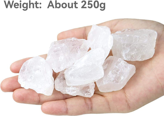 Hand holding clear quartz rough stones, translucent white crystal chunks