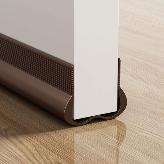 Brown door draft stopper strip cushion with U-shaped seal under white door gap