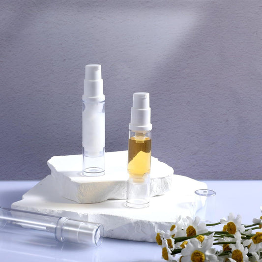 Two clear airless pump bottles with white pump heads, refillable travel dispensers
