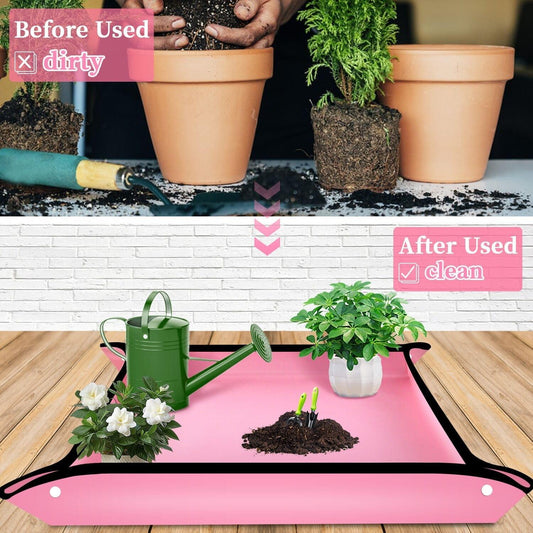 Pink plant repotting mat with black trim, unfolded on floor with potted plants and soil