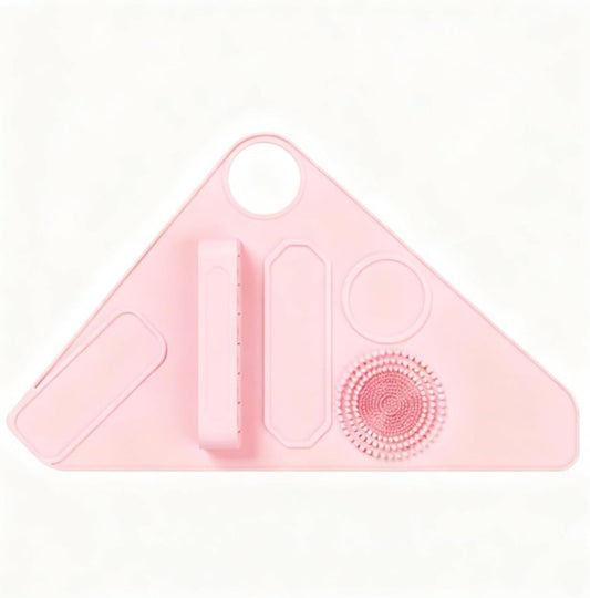 Pink silicone makeup wristband with triangular palette, brush holder, and cleaning texture