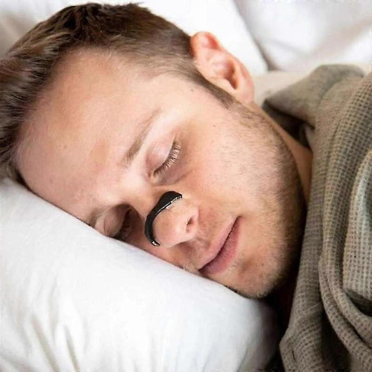 Nasal breathing strip on man's nose while sleeping on a pillow