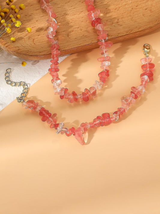 Pink faceted bead bracelet with gold-tone chain clasp, angled view
