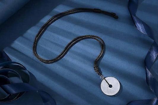 Round crystal pendant necklace with pale disc on black adjustable cord