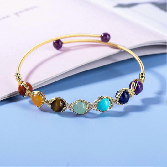 Gold wire crystal bead bracelet with purple end beads and blue, green, orange stones