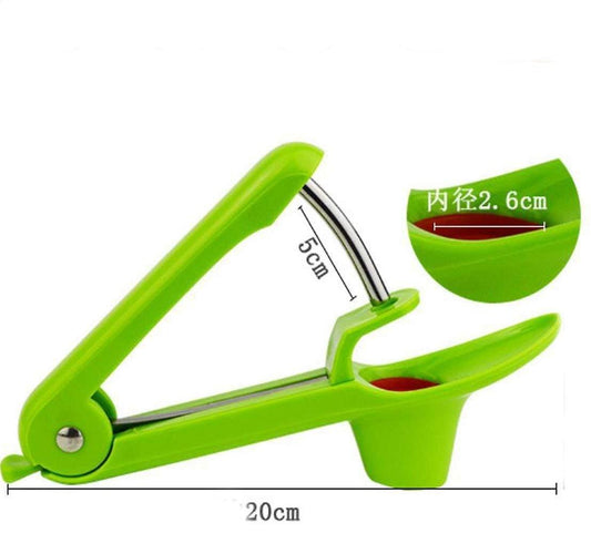 Green cherry pitter tool at angle with metal lever and red cherry cup