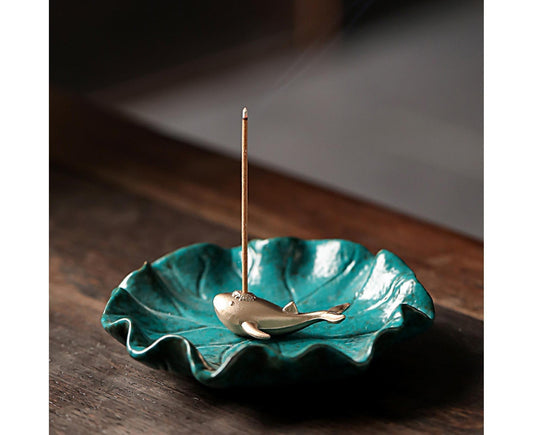 Ceramic lotus incense burner with teal bowl, brass holder, and incense stick