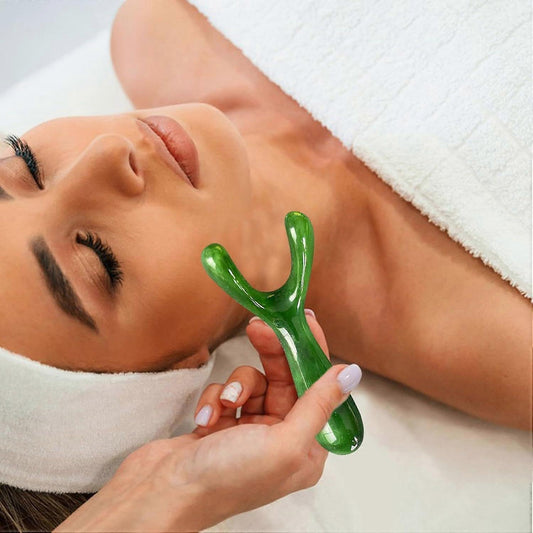 Green resin nose gua sha tool placed on the nose and cheek during massage