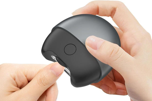 Electric nail clipper in dark gray housing, side view with cutting opening