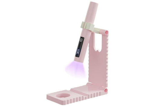 Pink cordless mini LED nail lamp glowing during curing