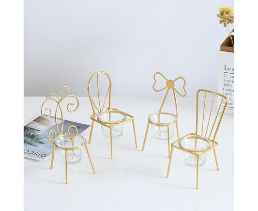 Set of four iron chair candle holders with clear glass cups, gold scroll designs