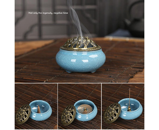 Ceramic incense burner bowl in light blue with ornate golden domed lid on wooden table