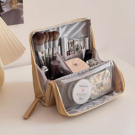 Portable toiletry bag with open compartments and mesh front pocket, beige exterior, gray lining