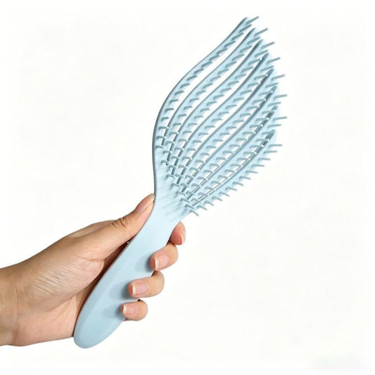 Light blue detangling hair brush held in hand, wide comb teeth on oval head