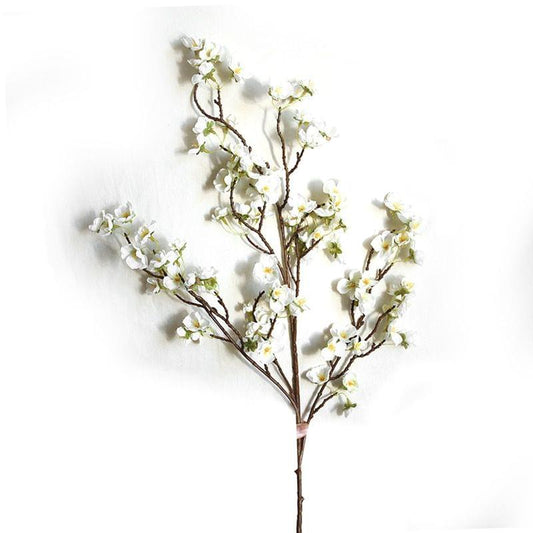 Artificial cherry blossom branch with white blossoms and green buds on dark brown branches