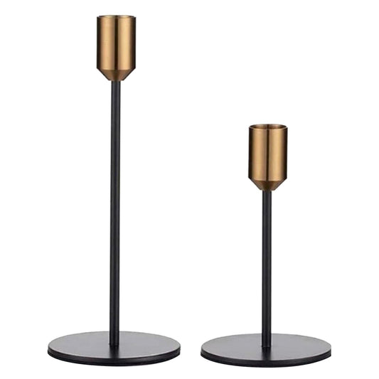 Two metal candle holders with black stems, antique gold top cups, and round bases