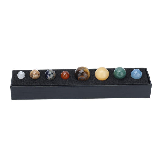 Black box tray holding eight crystal spheres with planet-style patterns