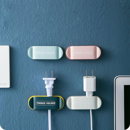 Wall-mounted power plug holders set: silver and rose holders on wall with plug adapters.