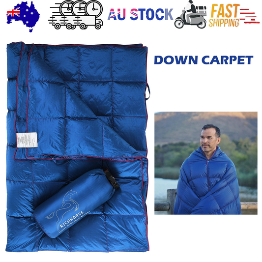 Blue packable puffy down camping blanket with red zipper and stuff sack