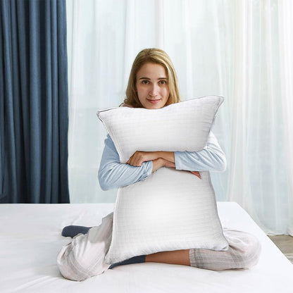 White quilted bed pillow with a smooth cover, held in a pair of arms